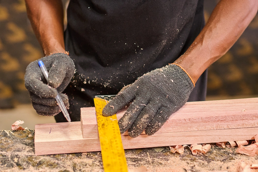 close up shoot showing Majeurs workman making a measurement marking on a wood piece